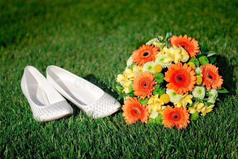 Bridal Bouquet and White Shoes Bride Lying on the Grass Stock Photo