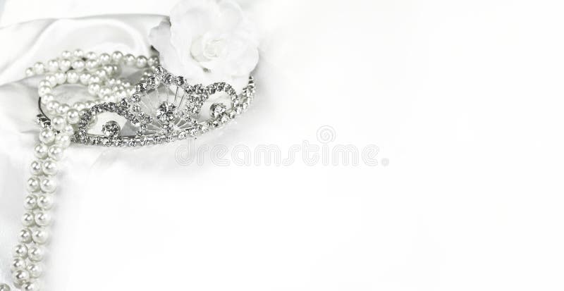 Bridal wedding decorations soft white bride background, silver crown and pearls on satin with space for text