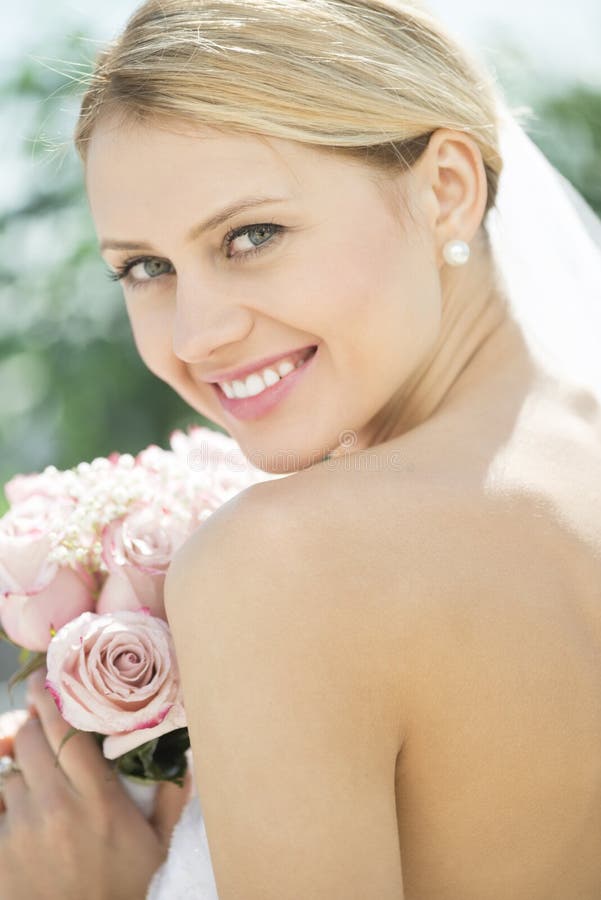 Bride In Backless Wedding Dress Holding Flower Bouquet