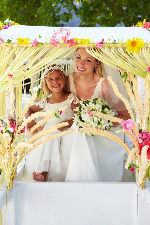 Bride And Bridesmaid Sitting Under Decorated Canopy stock photos