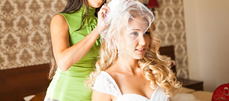 Bride getting ready for wedding in hair dressing. Behind, hairstyle.