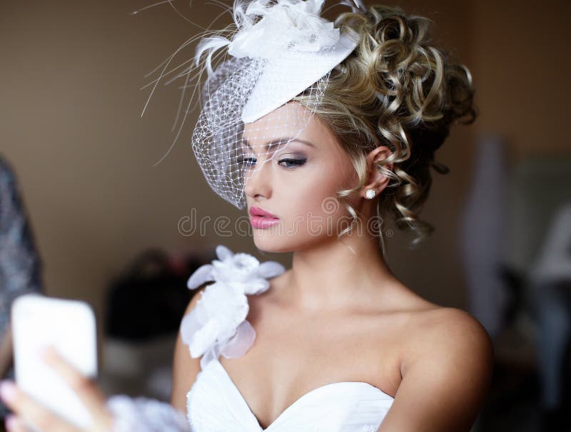 Bride girl in wedding dress looking in mirror