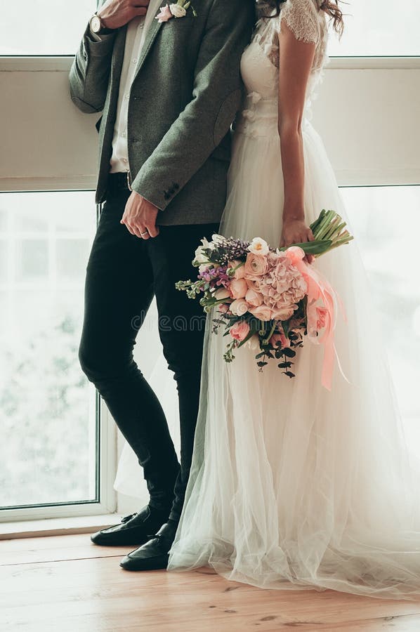 Side view of Bride and Groom standing by the window royalty free stock images Side view of Bride and Groom standing by the window royalty free stock images