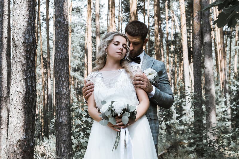 The Bride and Groom Embrace in the Forest on the Wedding Day. Wedding ...