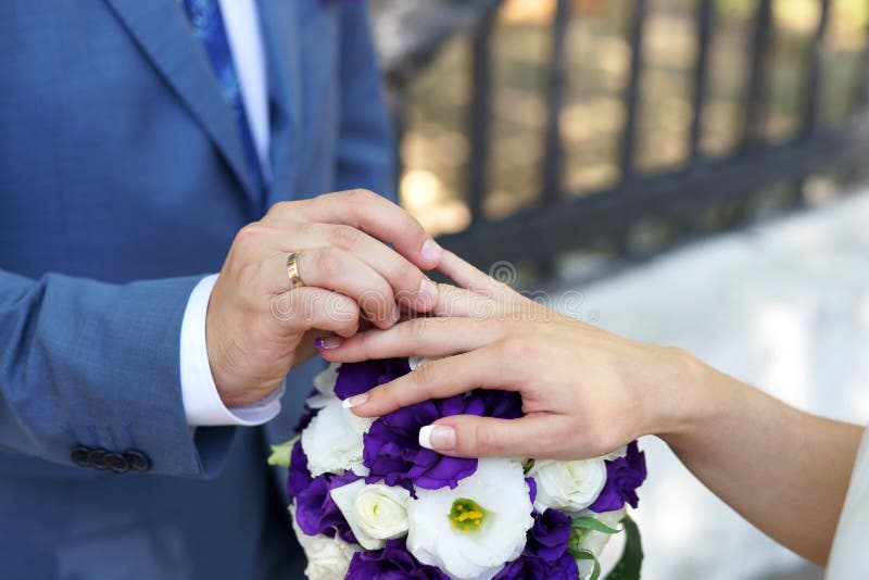 Bride and groom exchange wedding rings