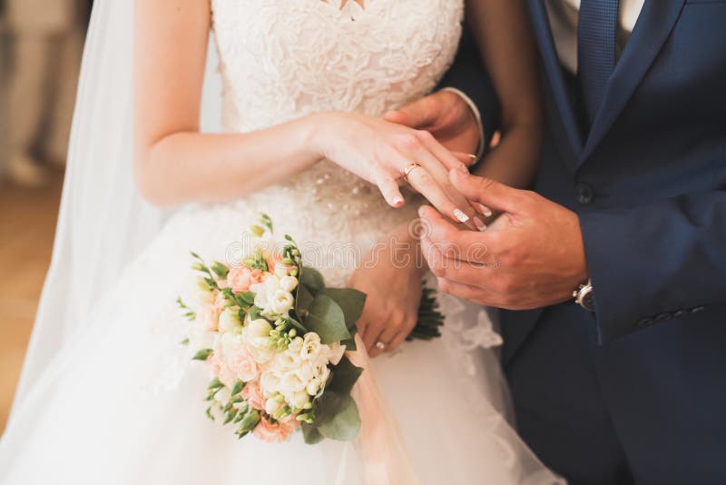 Bride and groom exchanging wedding rings. Stylish couple official ceremony