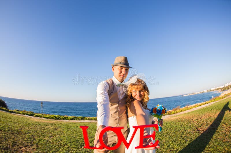 Bride and groom holding the letter word love royalty free stock photos Bride and groom holding the letter word love royalty free stock photos