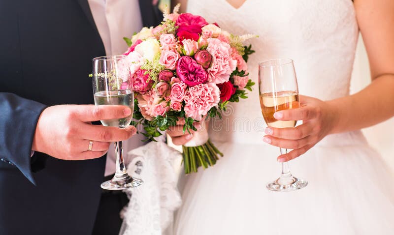 Bride and groom holding wedding champagne glasses close-up