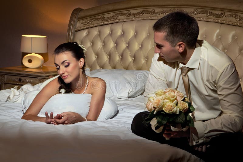 Bride and groom lying on bed