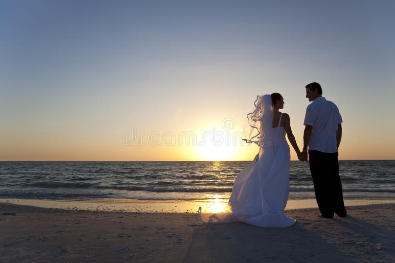 Svatbu manželé, nevěsta a ženich, spolu se západem slunce na krásné tropické pláži.