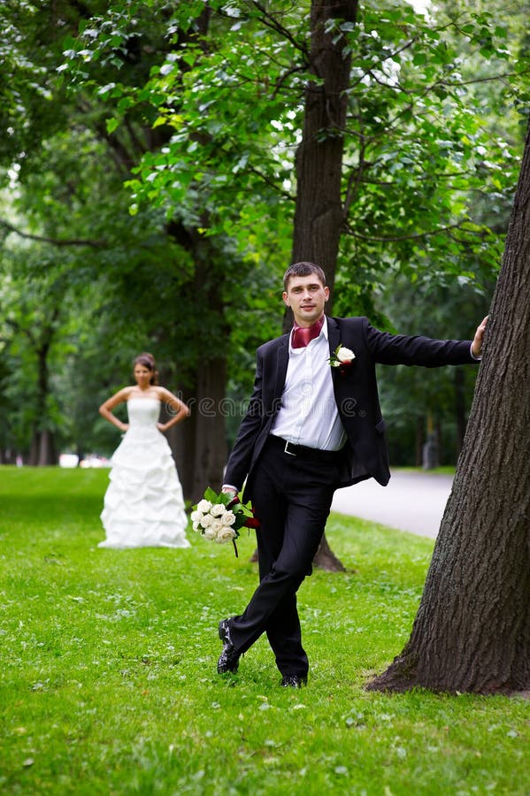 Bride and groom near trees in park