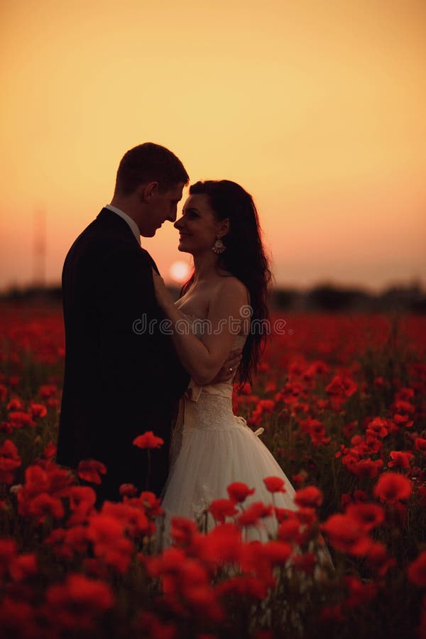 The bride and groom in a poppy field