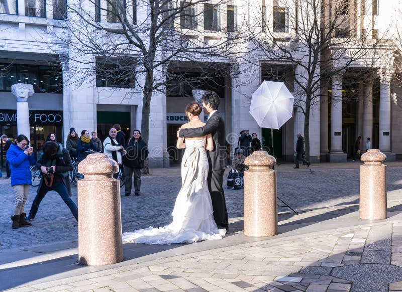 Bride and groom professional photographer wedding shoot near St Paul's Cathedral, London, UK. Bride and groom viewed from the back, with light-bouncing umbrella stock photos Bride and groom professional photographer wedding shoot near St Paul's Cathedral, London, UK. Bride and groom viewed from the back, with light-bouncing umbrella stock photos