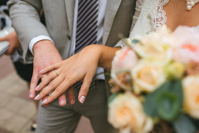 The bride and groom show their hands with gold rings near the wedding bouquet. royalty free stock photos The bride and groom show their hands with gold rings near the wedding bouquet. royalty free stock photos