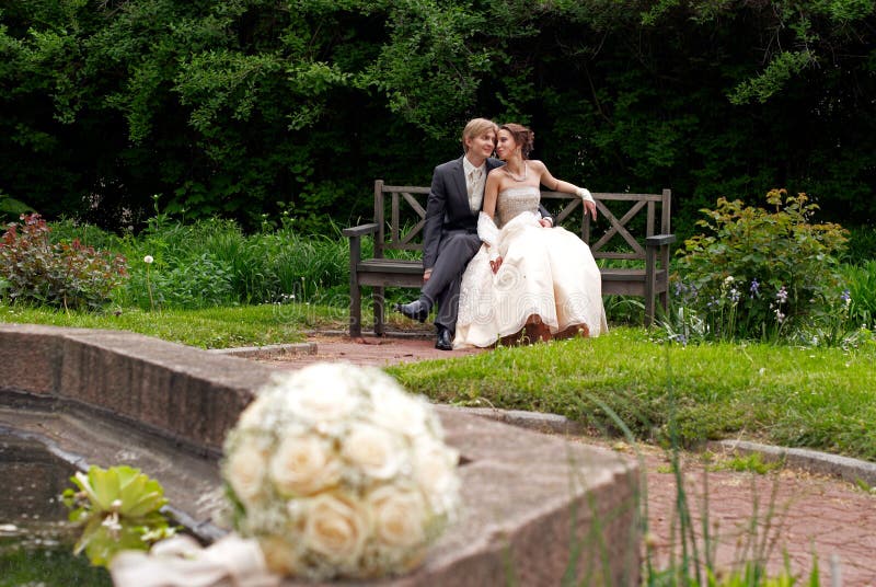 Bride and groom sitting in the park