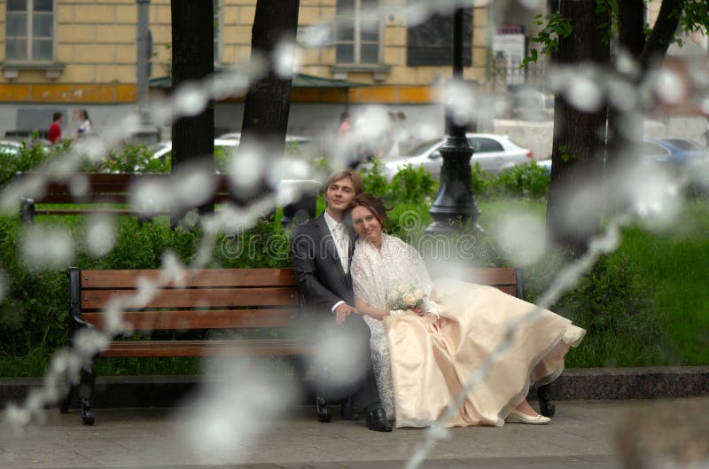 Bride and groom sitting in the park