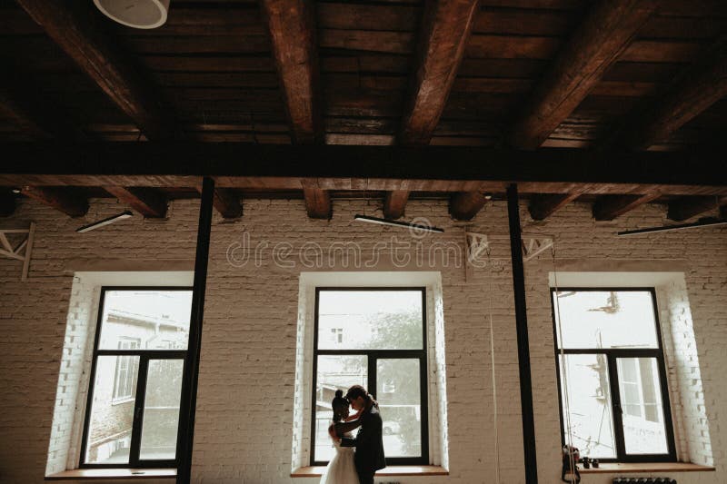 Bride And Groom Stand Near The Window Interracial Marriage Asian