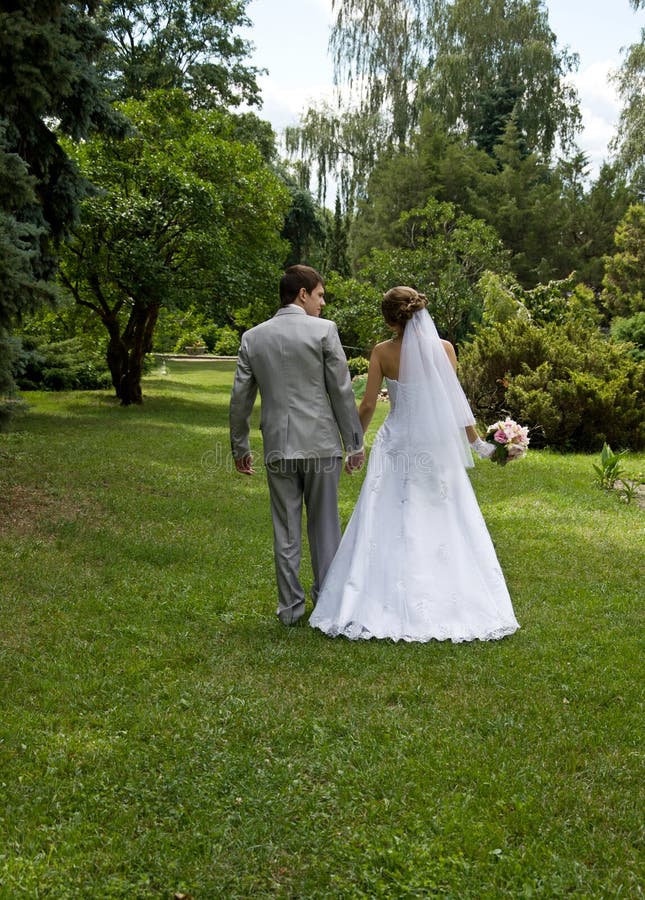 Bride and groom walking in a park