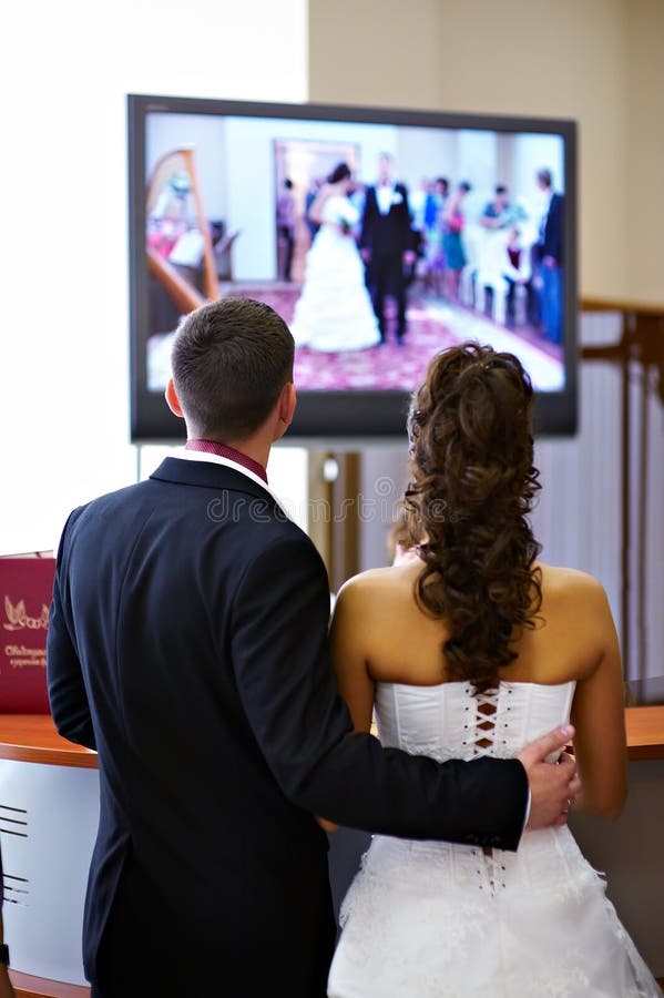 Bride and groom watch the video of his wedding