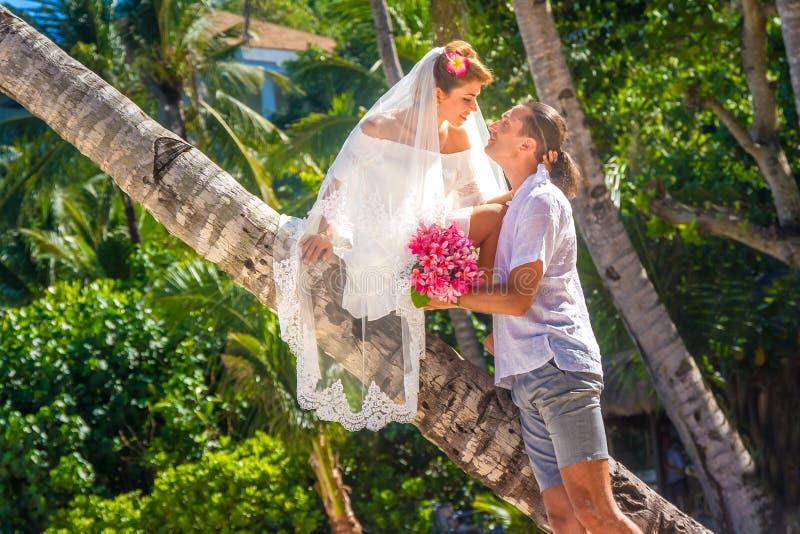 bride and groom, young loving couple, on their wedding day, outdoor beach wedding on tropical beach and sea background