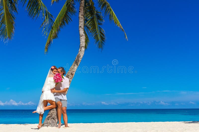 bride and groom, young loving couple, on their wedding day, outdoor beach wedding on tropical beach and sea background