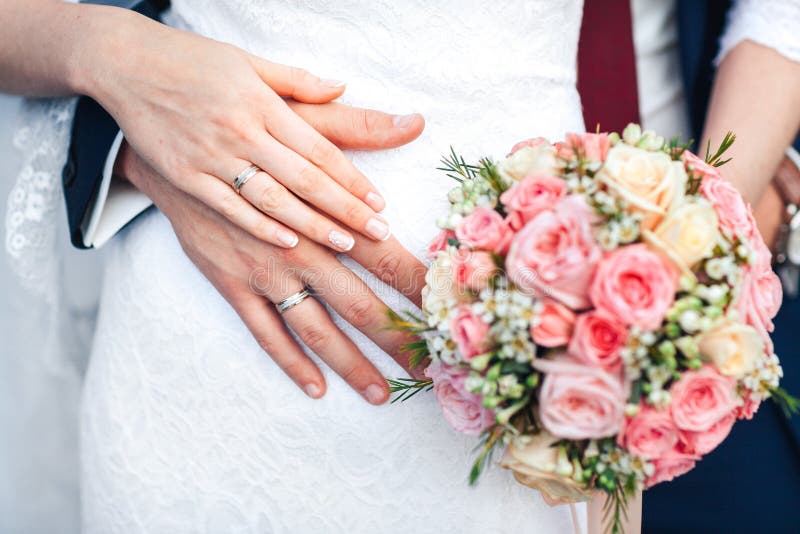 Bride Hand with Ring and Wedding Bouquet of Flowers Stock Photo Image
