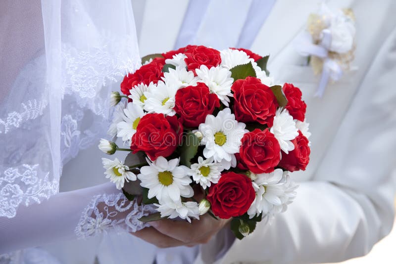 Bride holding beautiful red roses wedding bouquet