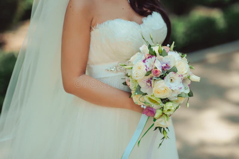 Bride holding big wedding bouquet on wedding ceremony. Bloom, beauty.