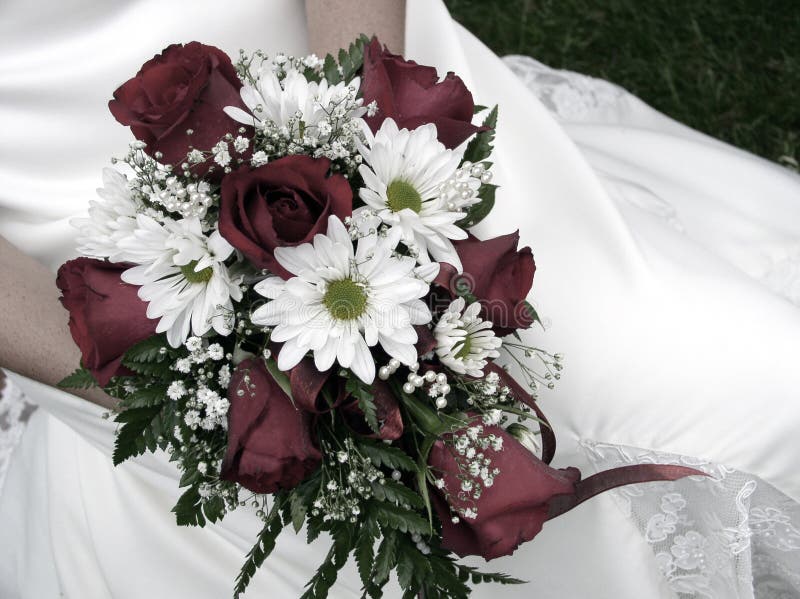 Bride holding her wedding bouquet against her dress