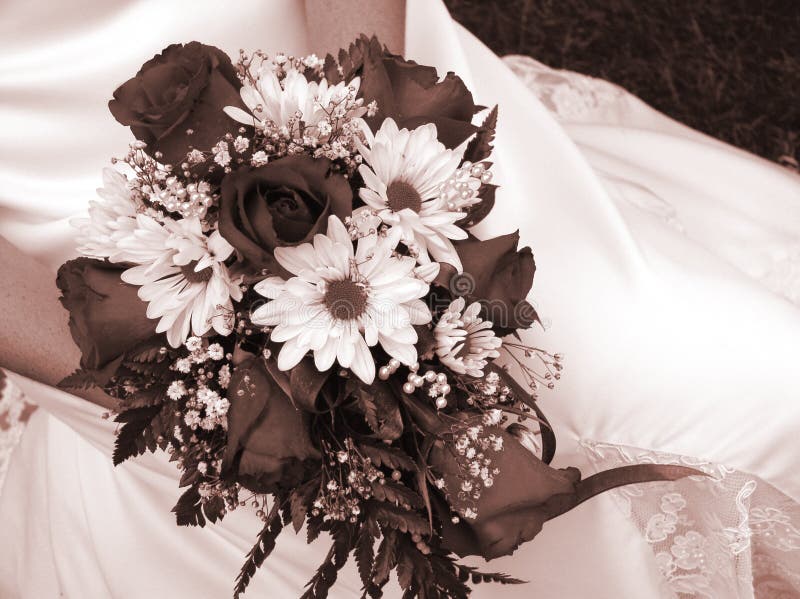 Bride holding her wedding bouquet against her dress