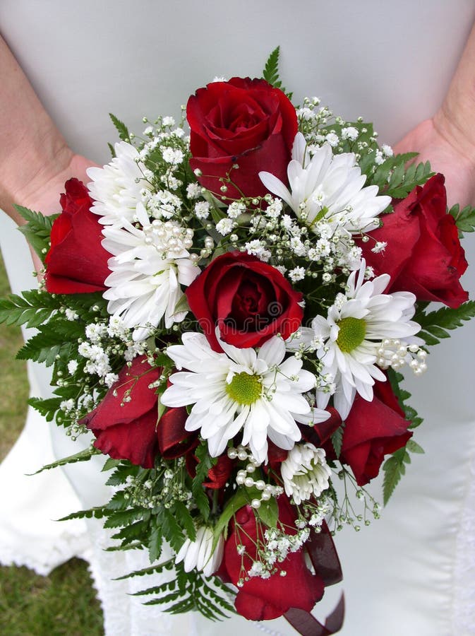 Bride holding her wedding bouquet against her dress