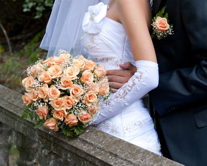 Bride holding orange bouquet detail