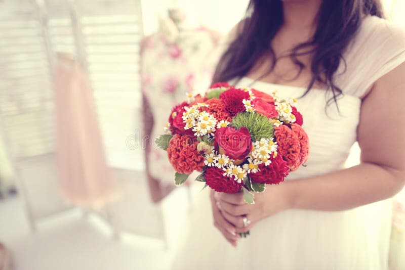 Bride holding red bouquet. Bridal, gown.