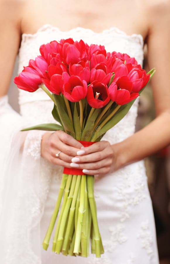 Bride holding a red tulips bouquet wedding day
