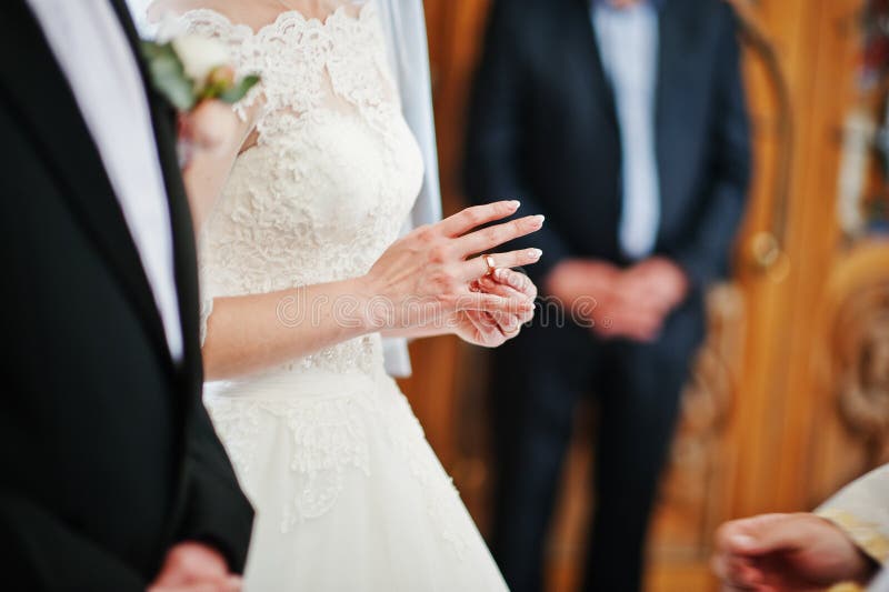 Bride Puts Wedding Ring at Hand on Church. Stock Photo Image of groom