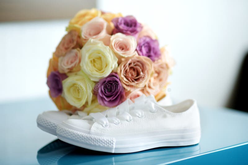 Bride`s white sneackers and beautiful bridal bouquet