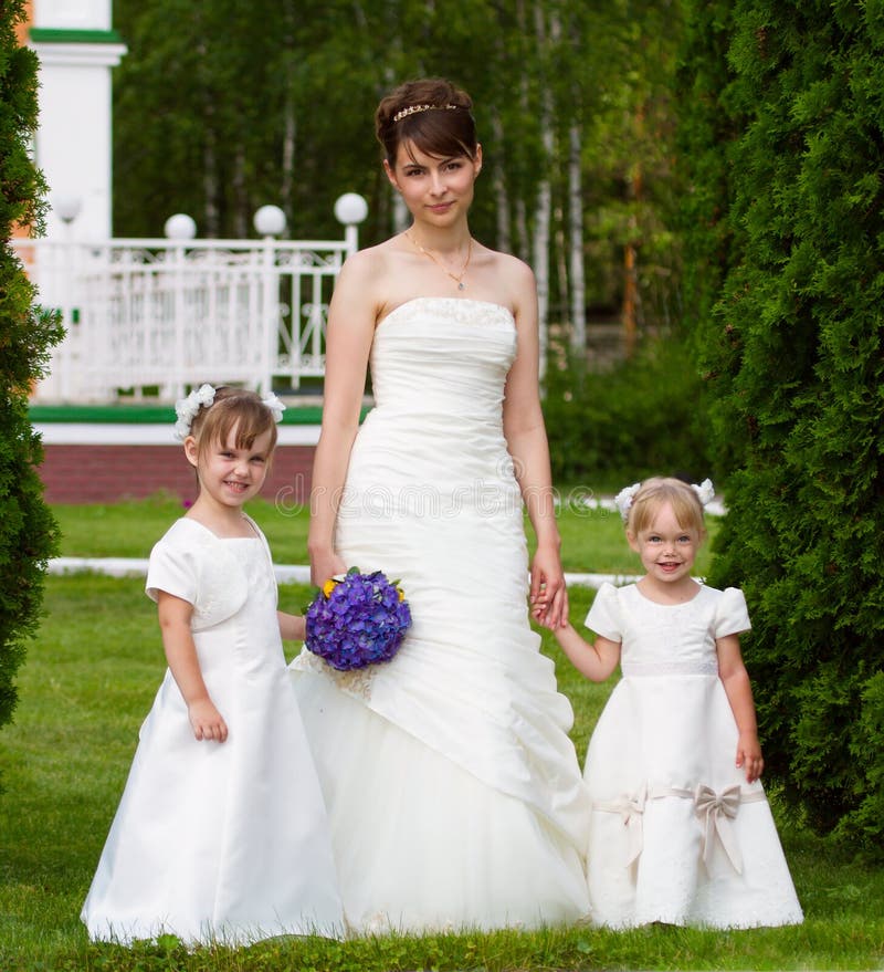 Bride stand with two little girls - bridesmaid