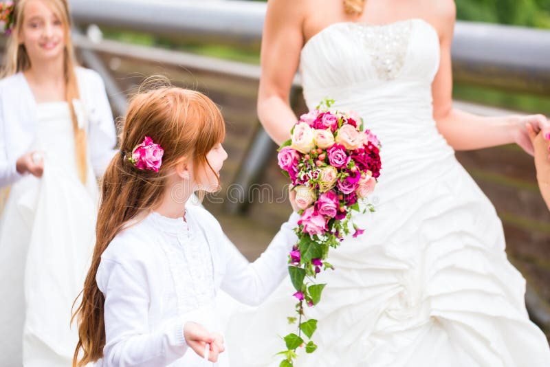 Wedding couple bride and groom with flower children or bridesmaid in white dress and flower baskets. Wedding couple bride and groom with flower children or bridesmaid in white dress and flower baskets