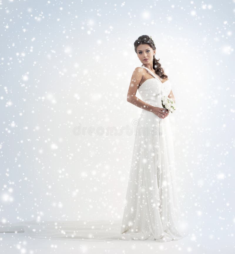 A bride in a white dress on a snowy background