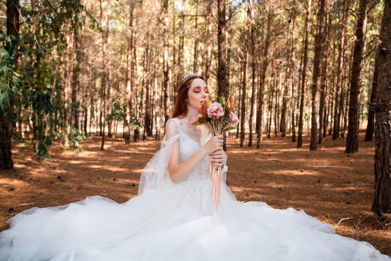 Bride with white wedding dress in forest holding colorful and dried wedding bouquet. royalty free stock photos Bride with white wedding dress in forest holding colorful and dried wedding bouquet. royalty free stock photos