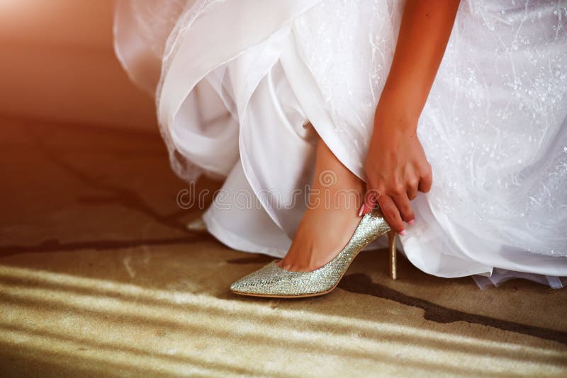 Premium Photo  Bride wearing wedding dress putting on her shoes while  getting ready for the ceremony