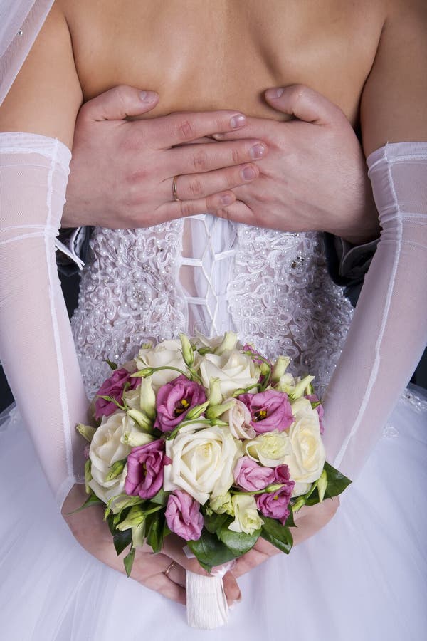 Bridegroom embraces his bride