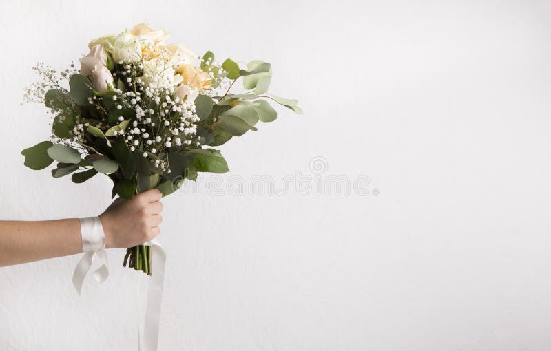 Bridesmaid som håller bröllopsbukett på vitt royaltyfri bild Bridesmaid som håller bröllopsbukett på vitt royaltyfri bild