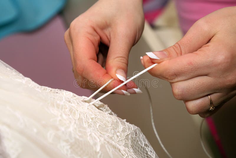 Bridesmaids помогают ей положить дальше платье свадьбы стоковые изображения rf Bridesmaids помогают ей положить дальше платье свадьбы стоковые изображения rf