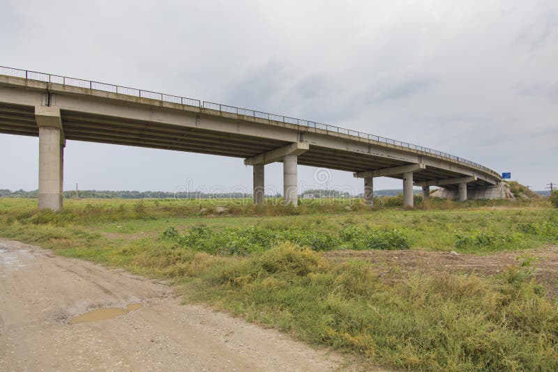 Countryside road passing under a highway bridge