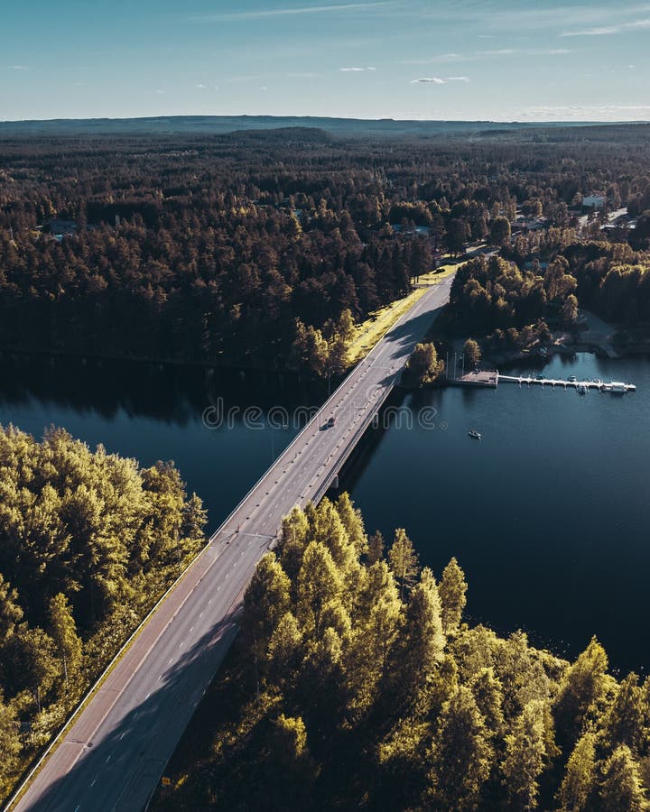 Bridge over water at Hyrynsalmi Finland with sunshine and some buildings