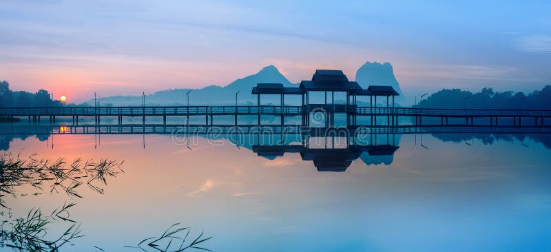 Bridge and pavilion on lake at sunrise park. Hpa-An, Myanmar