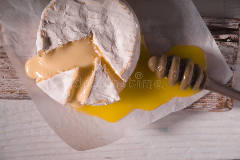 Brie Cheese, Slice, Honey on Parchment and on a Stand Stock Image