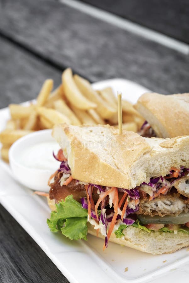 Briet zerschlagenes frisches Fischfiletsandwich mit Kohlsalatsalatpommes-frites und -Remoulade stockfotografie Briet zerschlagenes frisches Fischfiletsandwich mit Kohlsalatsalatpommes-frites und -Remoulade stockfotografie
