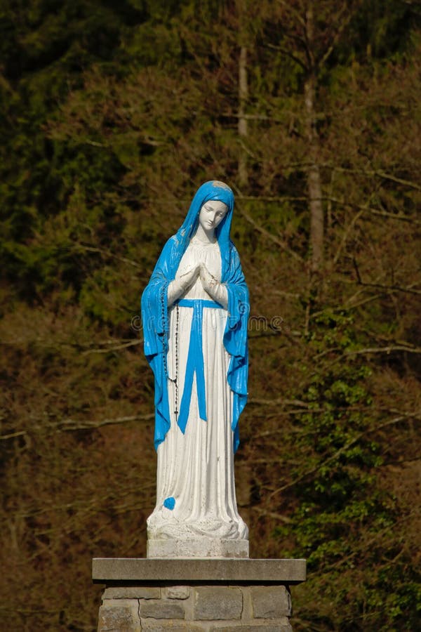 Brigh blå och vit staty av att be för dam Mary royaltyfri bild Brigh blå och vit staty av att be för dam Mary royaltyfri bild